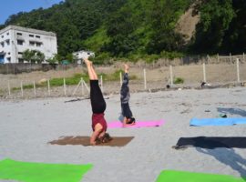 Student Posing Headstand On Banks of River Ganga – IYMS Rishikesh